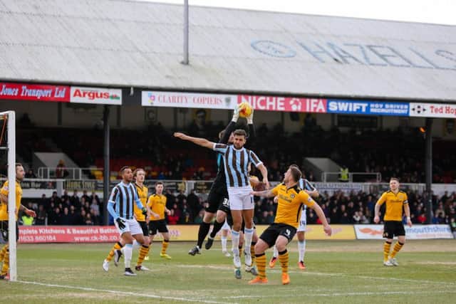 Mansfield Town's Ryan Tafazolli goes for the header - Pic Chris Holloway