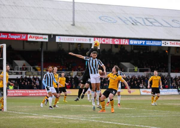 Mansfield Town's Ryan Tafazolli goes for the header  - Pic Chris Holloway