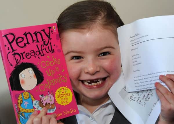 Isabella Rhodes with her signed book, reply letter and a copy of the letter that sparked an internet sensation after she wrote to author Joanna Nadin.