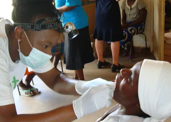 Hucknall dental nurse Monica Zendera, left, treats a patient in Zimbabwe.
