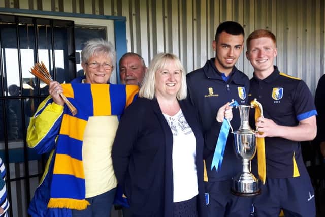 Julie Mather with friends Dave and Aleisha and members of the Stags youth team with their championship trophy.