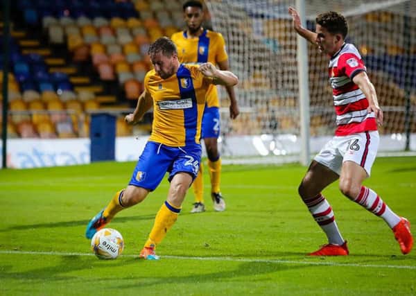 Mansfield Town's Jamie McGuire clears the danger - Pic by Chris Holloway
