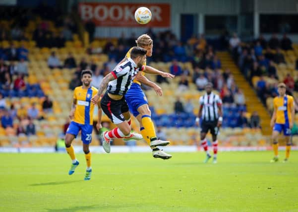 Mansfield Town's Kevan Hurst wins the header  - Pic by Chris Holloway
