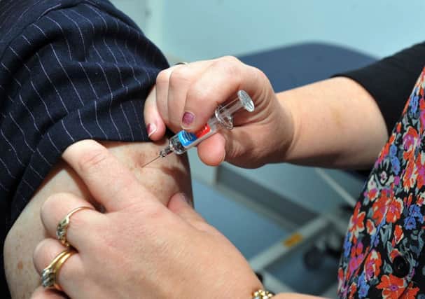 Nurse practitioner Julie Balmer, right, injects Doctor Kate Ardern, as she gets a flu jab to promote campaign to get members of the public vaccinated against the flu virus, at Worsley Mesnes Health Centre, Wigan.