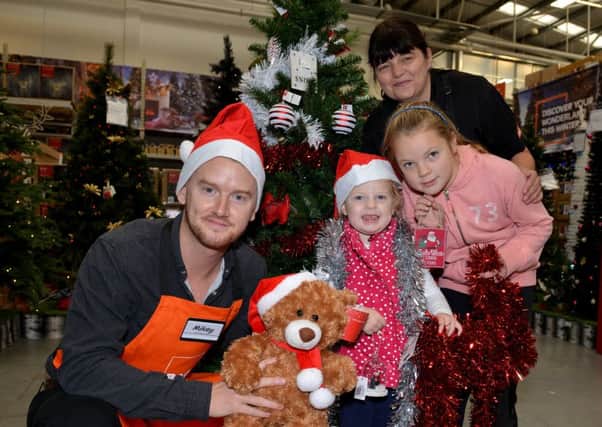Launch event at the new look B & Q store in Sutton In Ashfield, Coronation Street star Mikey North was set a DIY challenge, decorating a Christmas tree in five minutes, Mikey is pictured with B&Q staff member Alison, Jessie Warsop, three and Lily-May Warsop, eight