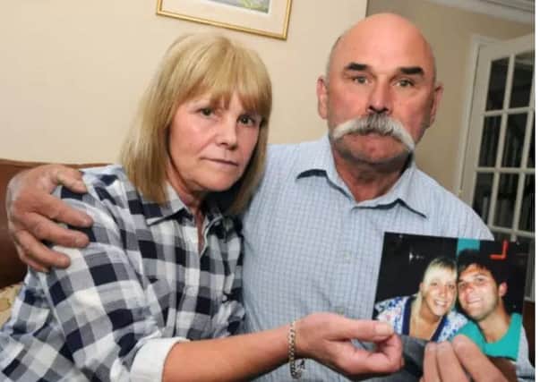 Sharon and Geoff Winter hold a photograph of their son Luke.