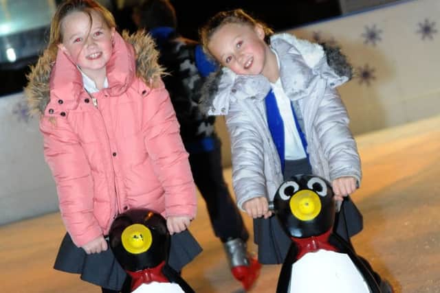 Nine year old Abbie Dysdale, left, and her 8 year old sister, Libbie, get some help around the rink from a couple of ice loving penguins during their visit to the Hucknall Christmas Festival on Wednesday.
