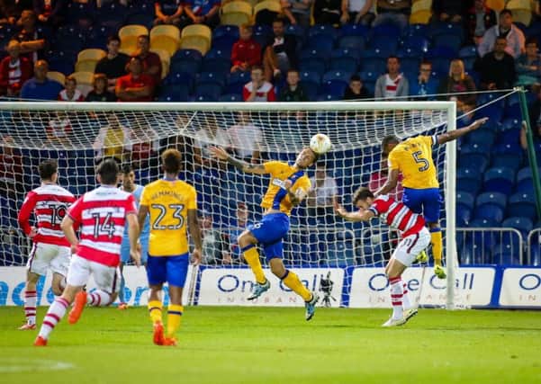 Mansfield Town's George Taft heads clear - Pic Chris Holloway