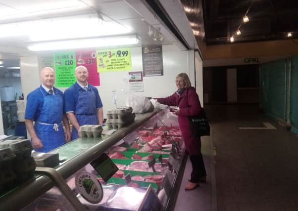 Malc Keeling serves a customer at Colleges Butchrs at idlewells indoor market, Sutton.