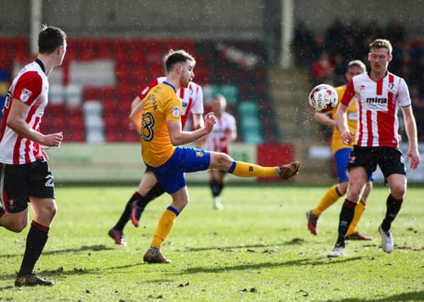 Mansfield Town's Ben Whiteman passes the ball on - Photo by Chris Holloway