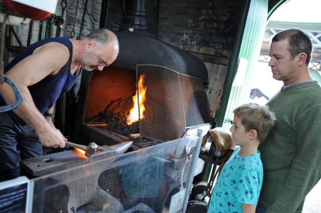 Eight year old Kobi Toogood and dad Garry Vaughan, check out the blacksmith shed where David Gill was hard at work during steam weekend at Papplewick Pumping Station.