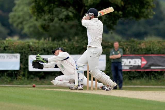 Welbeck wicketkeeper Stewart Groves dives to try and stop the ball after an attempted swipe by Hucknall batsman Geoff Dods.