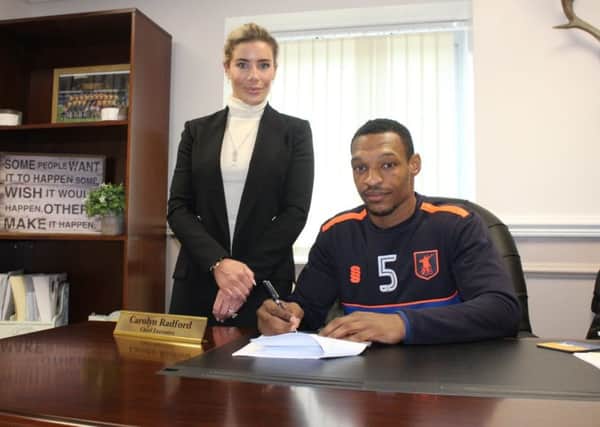 Krystian Pearce signs his new deal today watched by club CEO Carolyn Radford.