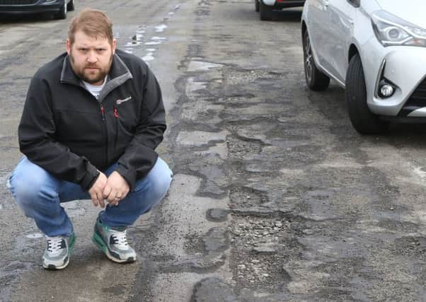 Furious resident Matt Tongue by some of the potholes on Auckland Road in Hucknall. (PHOTO BY: Jason Chadwick)